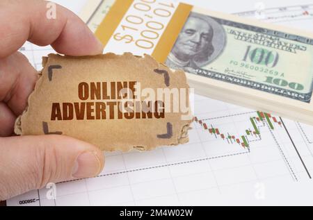 Business and finance concept. Against the background of dollars and a chart of quotations, a man holds a sign in his hands with the inscription - Onli Stock Photo