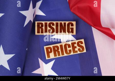 Economic concept. On the US flag, wooden blocks with the inscription - rising prices Stock Photo