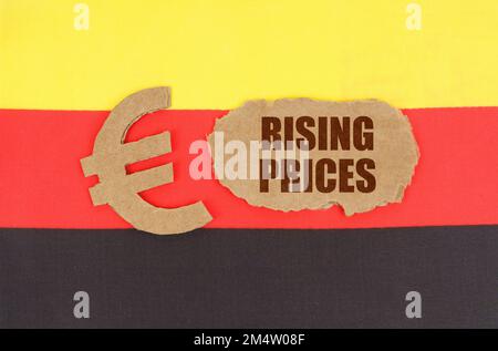 Economic concept. On the flag of Germany, the euro symbol and a cardboard plate with the inscription - rising prices Stock Photo