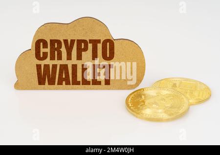 Business and technology concept. Bitcoins lie on a white surface and there is a sign - a cloud with the inscription - crypto wallet Stock Photo