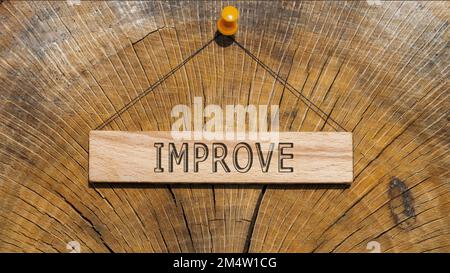 The word improve. Background stump written on wooden. Stock Photo