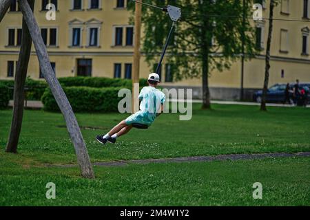 Boy swinging on rope at playground. Stock Photo