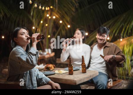 Woman holding a beer bottle drinking at a party Stock Photo