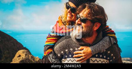 Excited and overjoyed happy mature young couple man and woman having fun together. Man carrying woman and both smile and laugh a lot in outdoor leisur Stock Photo