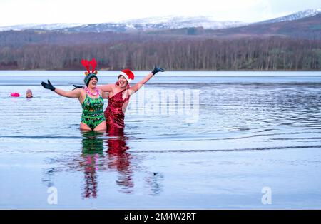 Members of the Loch Insh Dippers wild swim group take part in a Christmas-themed swim in Loch Insh in the Cairngorms National Park near Aviemore, Scotland. Picture date: Friday December 23, 2022. Stock Photo