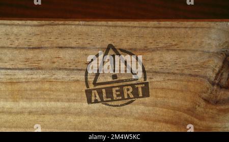 Alert stamp printed on wooden box. Danger alarm, security warning caution and attention concept. Stock Photo