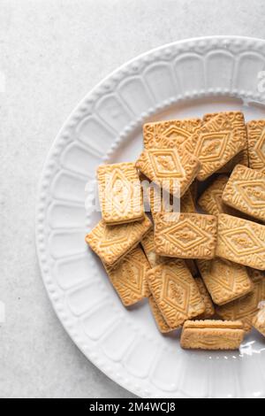 Sandwich cookies filled with cream on a white plate, Cream filled cookies, Top view of cookies on a plate Stock Photo