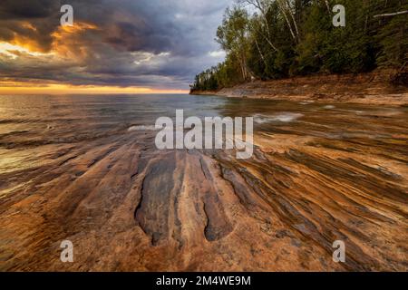Fading sunset shines over rock formations on Miners Beach on the shores of Lake Superior at Pictured Rocks near Munising in the Upper Peninsula of MI Stock Photo