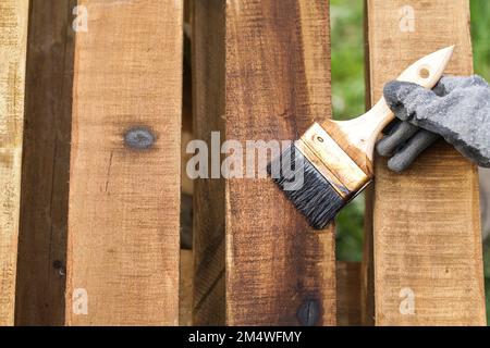 Stained Pallet Wooden. Outdoors Wood Surface Sealant Paintbrush Application Close-up Stock Photo