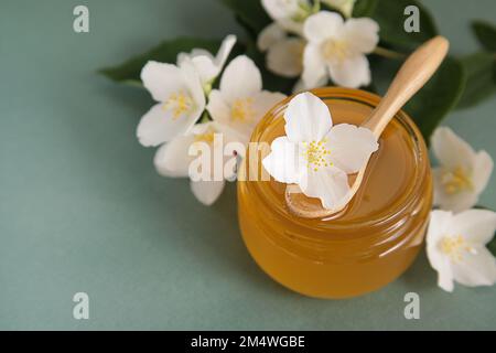 Jasmine honey, Jasmine flowers on green background. Herbal Medicine or Cosmetics. Copy space Stock Photo