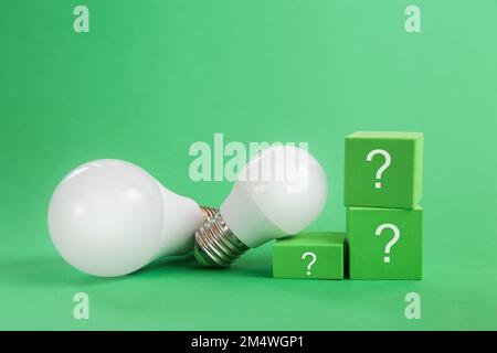 Light bulb, question mark on green background. Concept of competition for green energy market Stock Photo