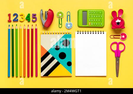 Stationary, back to school,summer time, creativity and education concept. Supplies - scissors, pencils, paper clips, note, stapler, calculator, notepad on yellow background, flatlay Mock up Top view. Stock Photo