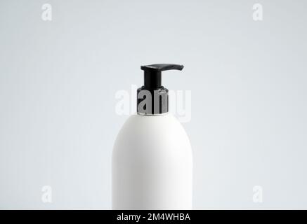White unbranded bottle with a black dispenser isolated on white background. cosmetic packaging mockup with copy space. Bottle for a shower, gel, soap. Stock Photo