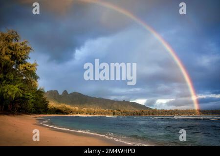 A rainbow appears over the Kalalea Mountain Ridge along the east coast of Kauai, Hawaii. Stock Photo