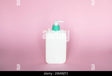 White unbranded bottle with a dispenser isolated on pink background. cosmetic packaging mockup with copy space. Bottle for a shower, gel, soap. Stock Photo