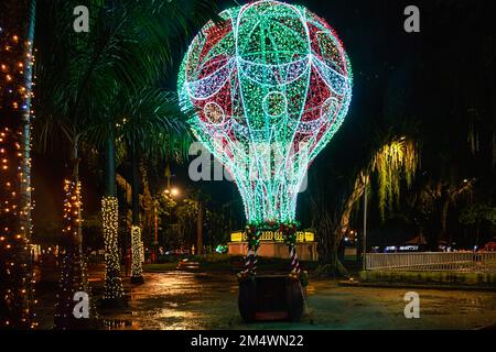 A Christmas ornament with the shape of a balloon. The decoration is illuminated in green and red colors. Stock Photo