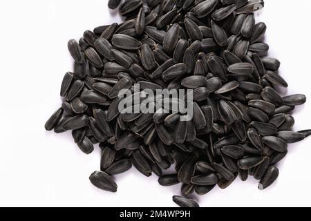 Heap of black sunflower seeds on a white background. Stock Photo