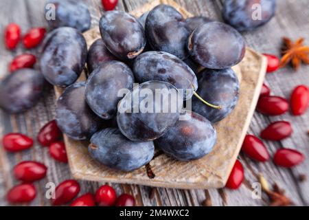 prune plums on wood background Stock Photo
