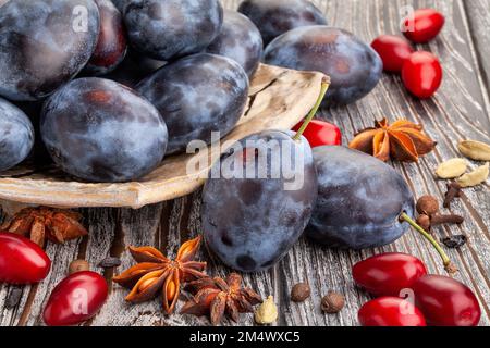 prune plums on wood background Stock Photo