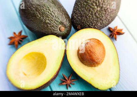 sliced hass avocado on wood background Stock Photo