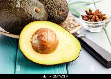 4 halved avocados sit on a cute cow-shaped wooden cutting board. A bowl of  fresh cucumbers sits in background. Dinner at home Stock Photo - Alamy