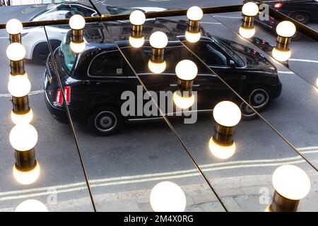 A Black london Cab is reflected in theatre lights shining into mirrors on the theatre ceiling.An unusual image and a unique angle of a London Taxi Stock Photo