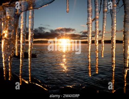 Icy Sunrise on Lake Tahoe - Icicles in front of rising sun landscape. Lake Tahoe, Califronia Stock Photo