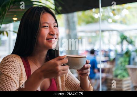 asian woman drinking coffee in a coffee shop Stock Photo