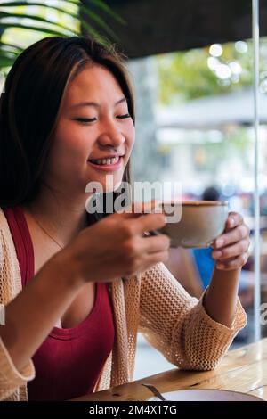 asian woman drinking coffee in a coffee shop Stock Photo