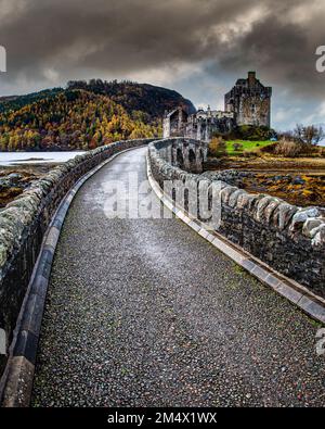 Portrait shot looking along the access path to Eilean Donan Castle at the mouth of Loch Duich on an autumn day Stock Photo