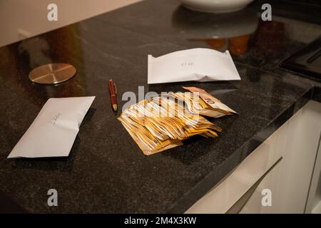 50 Euro and 10 Euro banknotes on a stone kitchen table with envelopes and ballpoint pen, fruit bowl in the background. High quality photo Stock Photo
