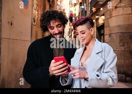 Friends using the mobile in the street Stock Photo