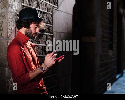 Man with a hat using a mobile in the street Stock Photo