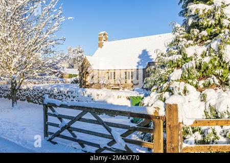 Early winter snow on the small stone church of St Mary in Hamlet (built 1958) in the Cotswold village of Birdlip, Gloucestershire, England UK Stock Photo