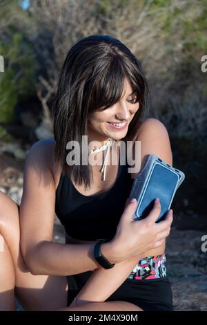 Woman touching screen of smart phone on armband Stock Photo