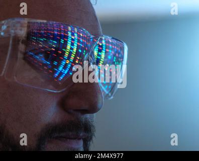 Scientist wearing protective eyeglasses analyzing DNA data in laboratory Stock Photo
