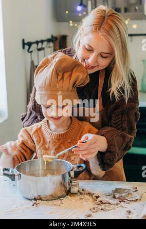 Happy mother and son preparing cookies at home Stock Photo