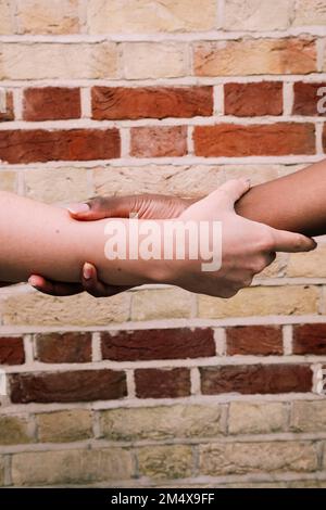 Multiracial friends holding hands in unity Stock Photo