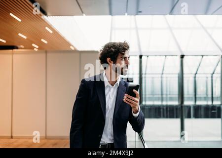 Young businessman holding smart phone Stock Photo