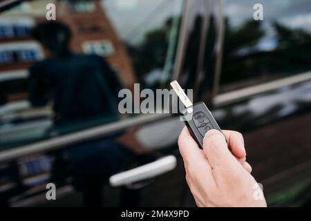 Hand of man unlocking car using key Stock Photo