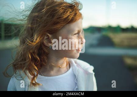 Thoughtful cute redhead girl with freckles, portrait Stock Photo