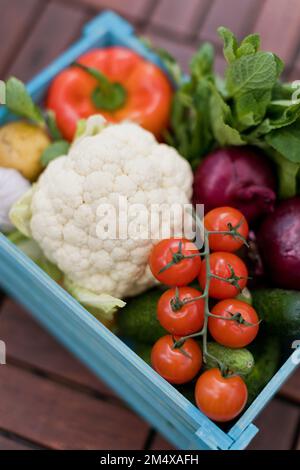 Fresh cherry tomatoes with organic vegetables in crate Stock Photo