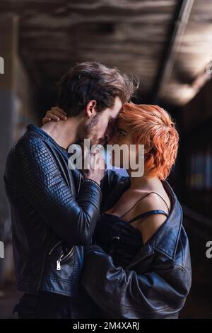 Affectionate young couple standing together in underpass Stock Photo