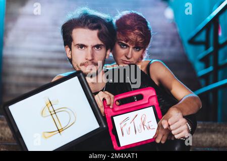 Confident young couple showing Dollar sign and text Stock Photo