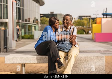 Happy senior couple sitting on bench Stock Photo