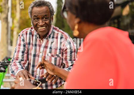 Smiling senior man looking at woman Stock Photo