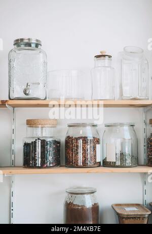 Dried fruits in jars arranged on shelves at shop Stock Photo