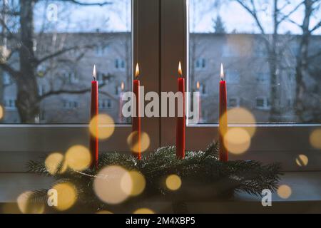 Flaming red candles on table at home in advent Stock Photo