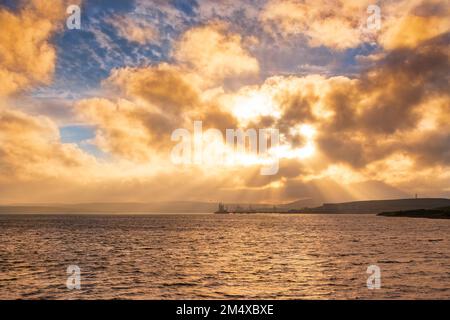 UK, Scotland, Dramatic sunset over Sullom Voe with oil terminal and gas plant in background Stock Photo