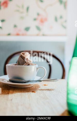 Empty coffee cup with crumpled napkin on table Stock Photo
